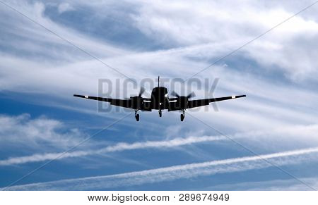 Airplane Silhouette Landing. Shape Of Private Jet Plane In The Blue Sky