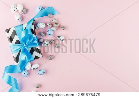 Gift With Blue Ribbon Small Easter Candy Eggs And Willow Twigs On Light Pink Background, Top View, C