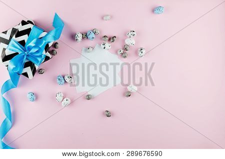Gift With Blue Ribbon Small Easter Candy Eggs And Willow Twigs On Light Pink Background, Top View, C