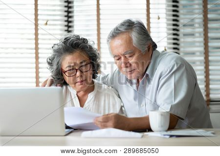 Stressed Asian Senior Couple Calculate Their Monthly Expense With Laptop Computer. Debts, Saving, Fi