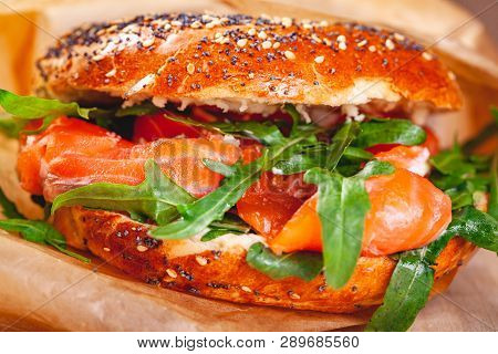 Bagel With Cream Cheese, Smoked Salmon And Arugula Salad In Brown Paper Bag. Close Up