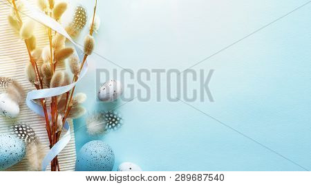 Easter Greeting Card With Colorful Easter Eggs And Sprin Flowersl On Blue Table. Top View With Space