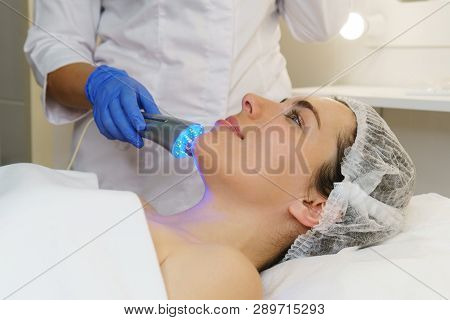 Hardware Cosmetology. Ultrasound Chromotherapy. Beautician Carries Out Procedure For Tightening Skin