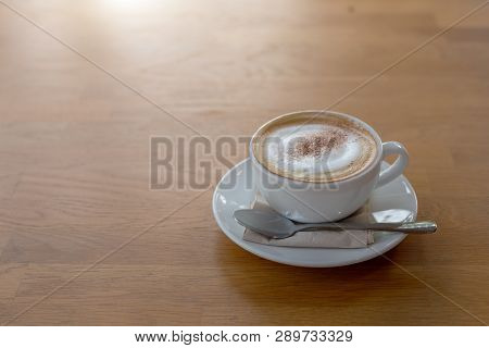 Cappucinno Coffee Cup On Wood Table With Morning Light. Hot Beverage For Wake Up Life
