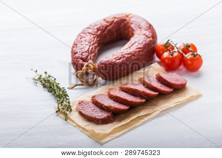 Food, Cuisine And Horsemeat Concept - Close Up Of Meat Sausage With Tomatoes And Pepper On Kraft Pap