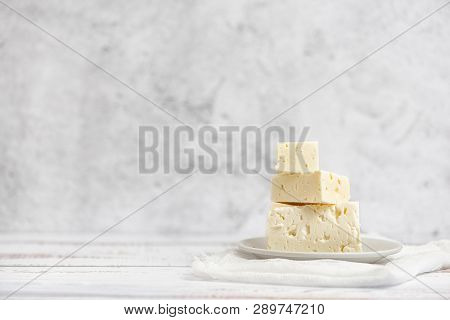 Sliced Feta Cheese On Light Background. High Key. With Copy Space.