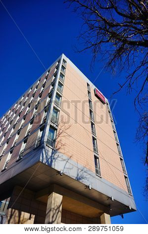 Poznan, Poland - October 31, 2018: High Mercure Hotel Building With Tree Twigs In Foreground.