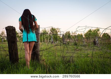 Portrait Of Young Beautiful Girl In A Turquoise Dress Near Barbed Wire In Summer Outdoor