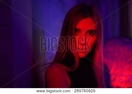 Sexy Young Beauty Woman Posing Over Night City Dramatic Red And Blue Neon Background