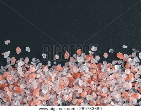 Himalayan Pink Salt In Crystals On Black Stone Background. Copy Space