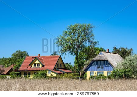 Building, Trees And Blue Sky In Wieck, Germany.
