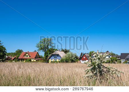Building, Trees And Blue Sky In Wieck, Germany.