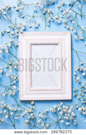 Empty Frame And  Fresh White Gypsofila  Flowers On Blue Textured Background. Top View. Flat Lay. Pla