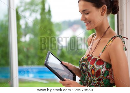 Csinos, fiatal mosolygó nő nézett tablet pc