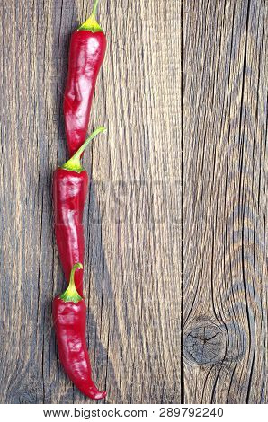 Background With Chili Peppers On Old Wooden Tablem Top View With Copy Space