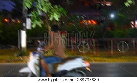 Blurred Images Of Men Wearing Brown Shirts Is Driving A Motorcycle Fast