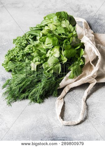 Healthy Green Vegan Ingredients For Cooking. Various Herbs And Keil In Textile Bag On Grey Backgroun