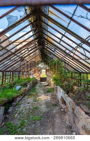 Look To Old Ruined Greenhouse. Broken Ancient Greenhouse With Broken Windows.