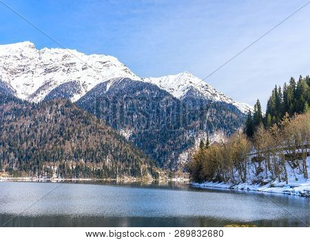 Mountains Covered With Forests And Snow On The Shores Of A Beautiful Mountain Lake