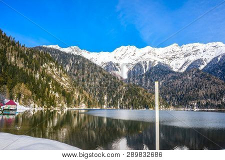 Mountains Covered With Forests And Snow On The Shores Of A Beautiful Mountain Lake