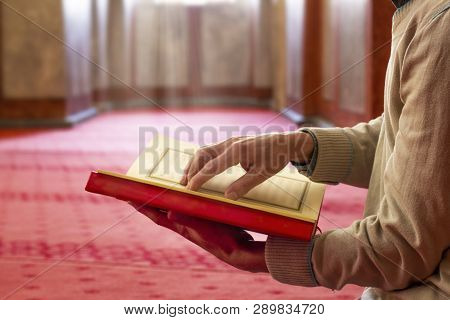 Unidentifiable Muslim Man Reading Quran Inside The Mosque