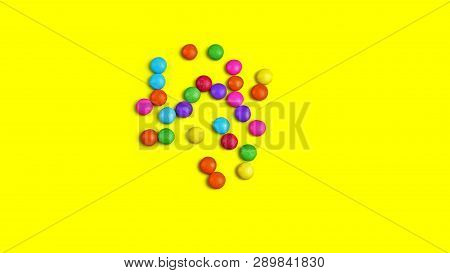 Colorful Chocolade Smarties On The Yellow Background.