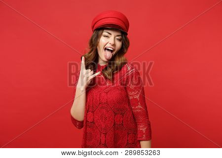 Portrait Of Crazy Young Woman In Lace Dress Cap Showing Tongue, Doing Horns Up Gesture Isolated On B