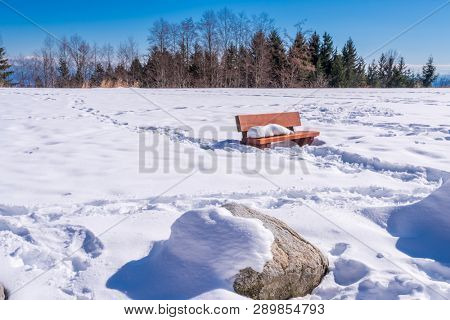 A park bench with gorgeous view at mountains and blule sky with white clouds, British Columbia, Canada.