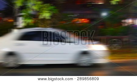 The White Car That Drives Quickly Makes The Image Become Blurred.