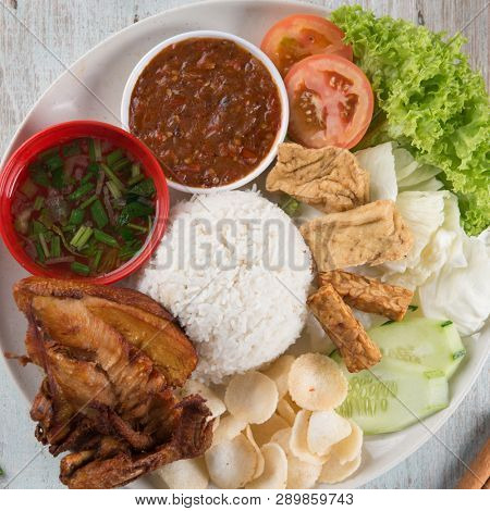 Nasi lemak kukus with fried chicken, popular traditional Malaysian local food. Flat lay top down overhead view.