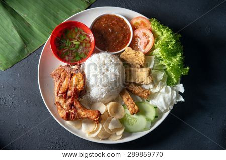 Nasi lemak kukus with fried drumstick, popular traditional Malaysian local food. Flat lay top down overhead view.