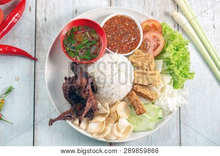 Nasi lemak kukus with quail meat, popular traditional Malaysian local food. Flat lay top down overhead view.