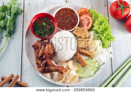 Nasi lemak kukus with fried drumstick, popular traditional Malaysian local food. Flat lay top down overhead view.