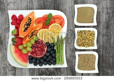 Super food and herbs for weight loss concept with fresh fruit and vegetables with herbs used in herbal medicine to help lose weight and suppress appetite. Top view on rustic wood.