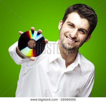 portret przystojny młody mężczyzna trzyma cd na zielonym tle