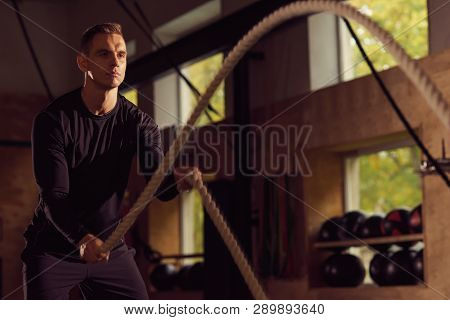 Fit, Sporty And Athletic Sportsman Working In A Gym. Man Training Using Battle Ropes. Sports, Athlet
