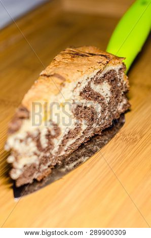 Delicious Homemade Chocolate Cake With Cottage Cheese On The Wooden Table Background. A Piece Is Cut