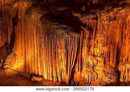 Background With Cave Yellow Flowstones, Stalactites And Stalagmites