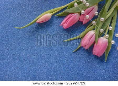 Pink Tulips With Pearls On Blue Glitter Background With Copy Space