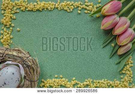 Easter Background With Red Tulips, Yellow Sand Frame And Egg On Green Glitter Background With Copy S