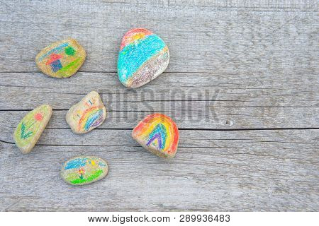Background From A Naturally Old Wooden Board On Which Lie The Pebbles Painted With Pencils.