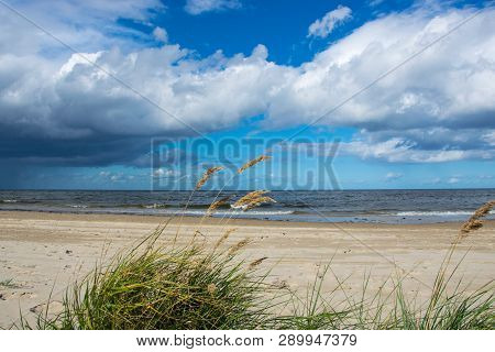 Bright Sun And Dark Rain Clouds Above The Baltic Sea.