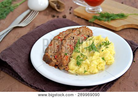 A Meatloaf With Mushrooms And Red Sweet Pepper On A White Plate With A Garnish Of Mashed Potatoes. S