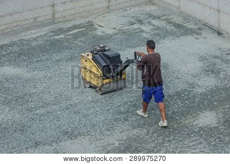 Limassol, Cyprus - November 4, 2018: Worker Using Small Mechanical Roller To Flatten Newly Levelled 