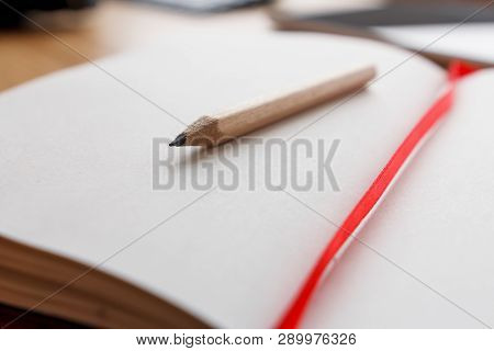 Close-up Of Open Notebook And Pencil, Red Book-mark.