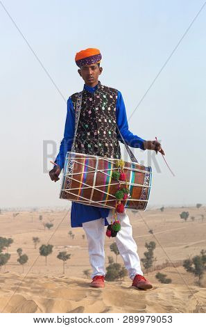 Bikaner, India - January 12, 2019: Young Indian Drummer In Traditional Clothes Performing During Cam