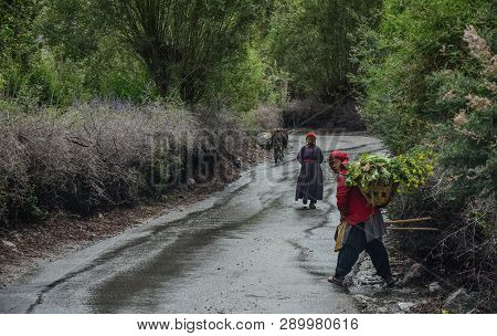 Tibetan People Walking On Rural Road