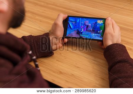 Prague, Czech Republic - March 16, 2019: Man Holding A Smartphone And Playng The Fortnite: Battle Ro