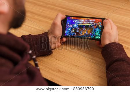 Prague, Czech Republic - March 16, 2019: Man Holding A Smartphone And Playng The Marvel Contest Of C