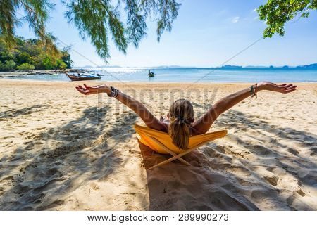 Woman enjoying her holidays on a transat at the tropical beach in Thailand